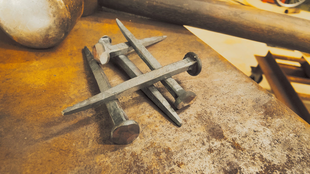 Forged nails stacked on an anvil