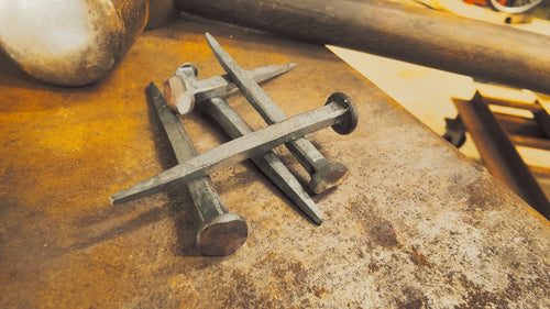 Forged nails stacked on an anvil